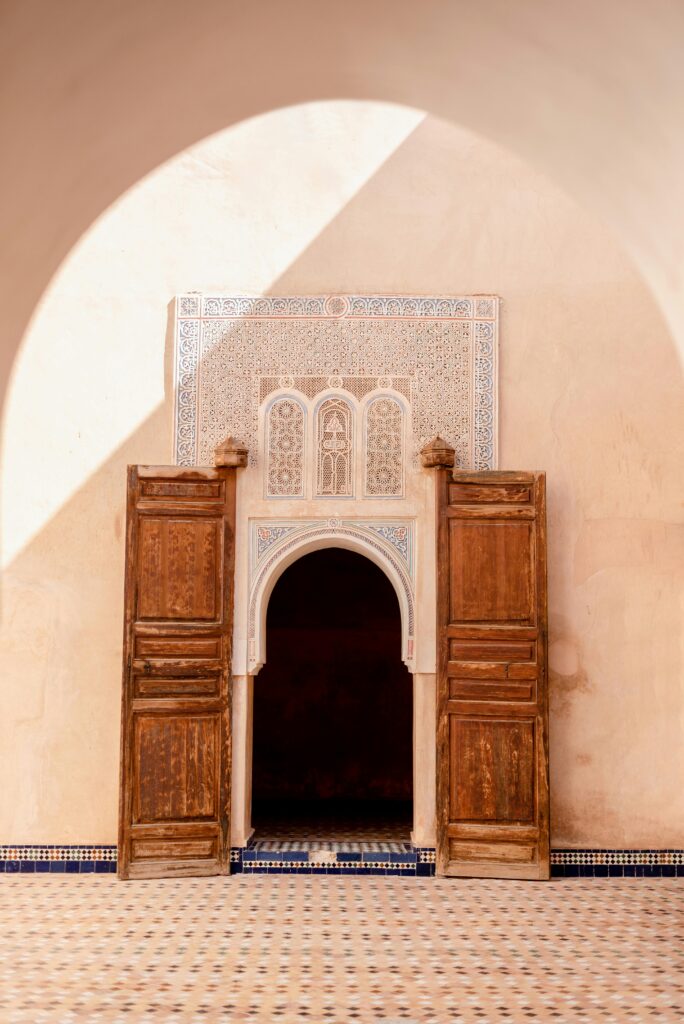 Beautiful Moroccan architecture featuring a wooden door and ornate archway in Marrakech, Morocco.